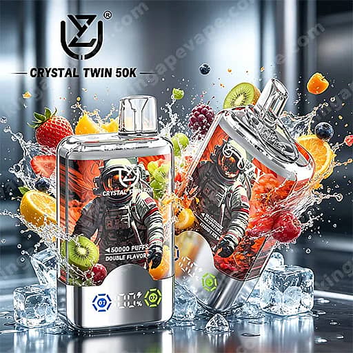 Dos dispositivos Crystal Twin 50K Vape con cuerpos rectangulares transparentes y marcos cromados, cada uno con una ilustración de un astronauta, rodeados de rodajas de frutas flotantes (fresa, kiwi, naranja, uvas) y cubitos de hielo con salpicaduras sobre una superficie reflectante.