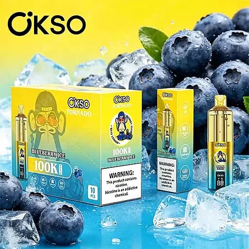 Heldergele achtergrond met Okso Blueberry Ice 100K vape-verpakking en een goudkleurig vape-apparaat, met een cartoonmascotte op de dozen, omringd door bosbessen en ijsblokjes.