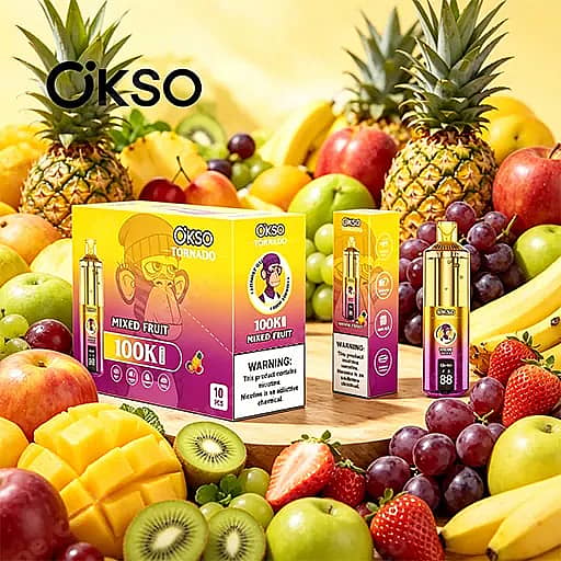 Heldere weergave van Ökso Tornado-verpakking met gemengde fruitsmaak en een fles, te midden van een kleurrijk assortiment vers fruit, waaronder ananas, mango's, kiwi's, druiven, aardbeien en appels.